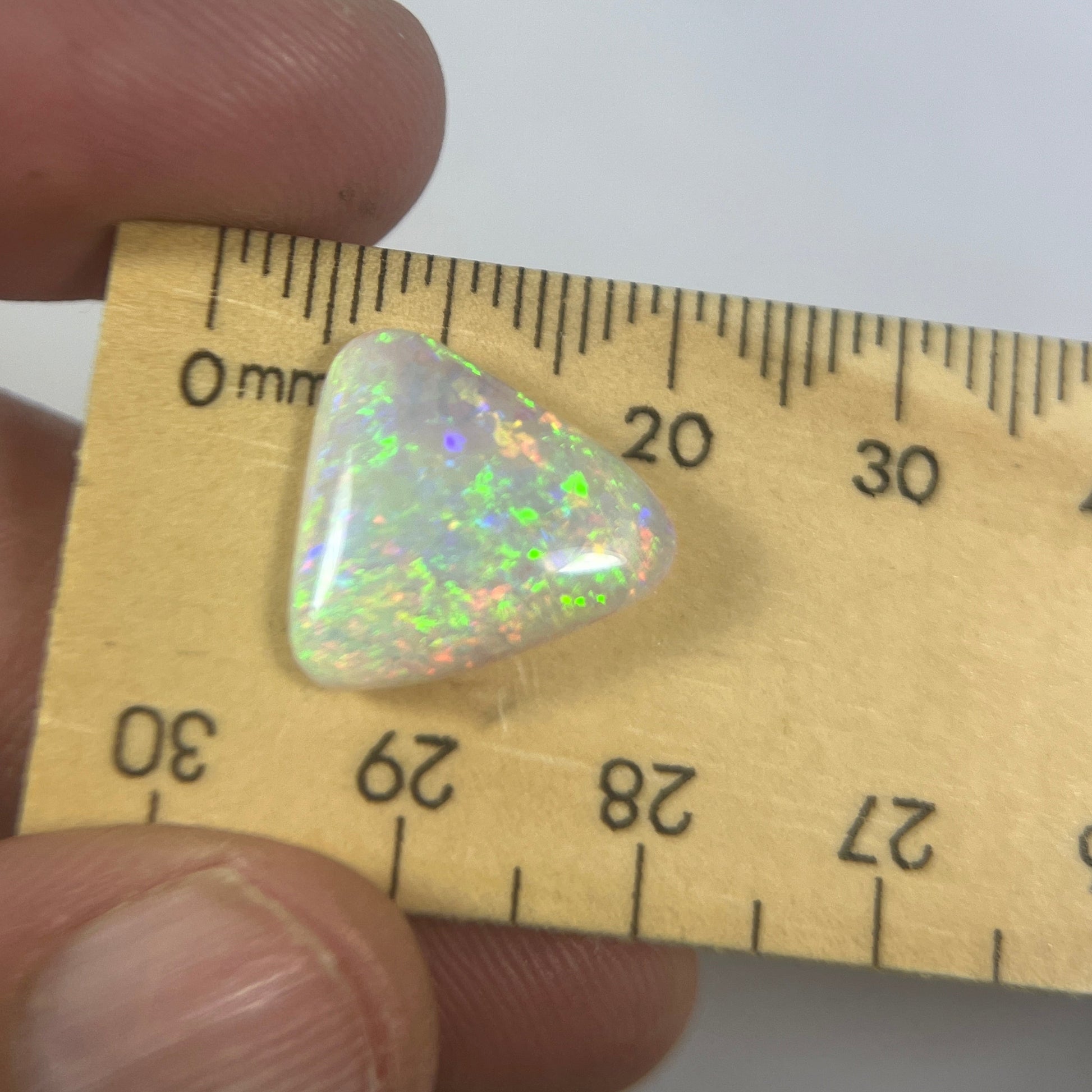 Stunning triangle shaped solid crystal opal from Grawin, Lightning Ridge.. A great shape and a spectrum of colours throughout including greens, blues and reds.