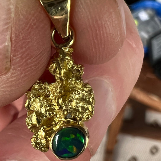 Pure solid gold nugget pendant from Western Australia. Perfectly set with an 18ct bale. Set with a beautifully cut black opal from Lightning Ridge.
