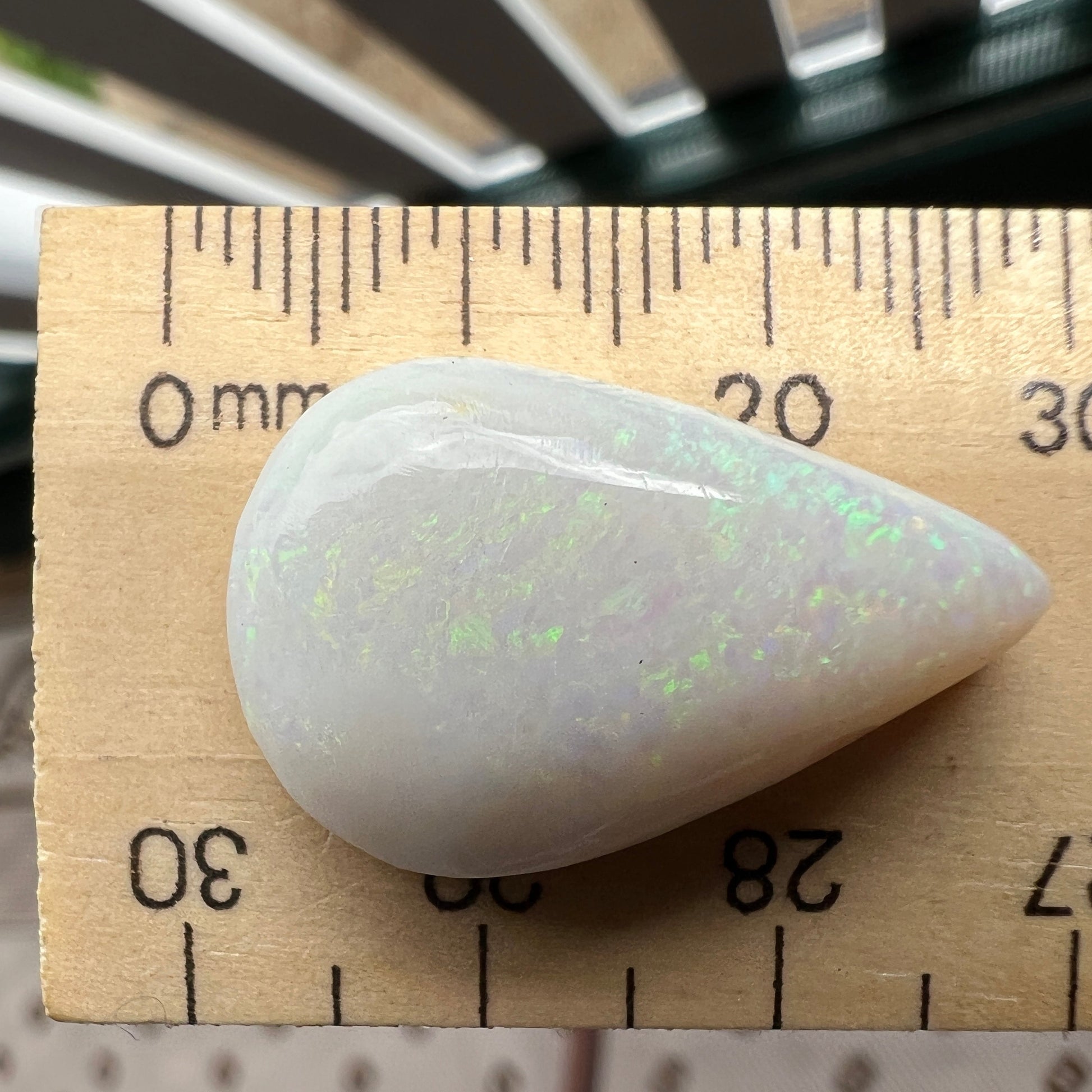 Large teardrop shaped solid white opal from Coober Pedy, featuring striking pinfire greens. Ready for a pendant. An excellent bargain.