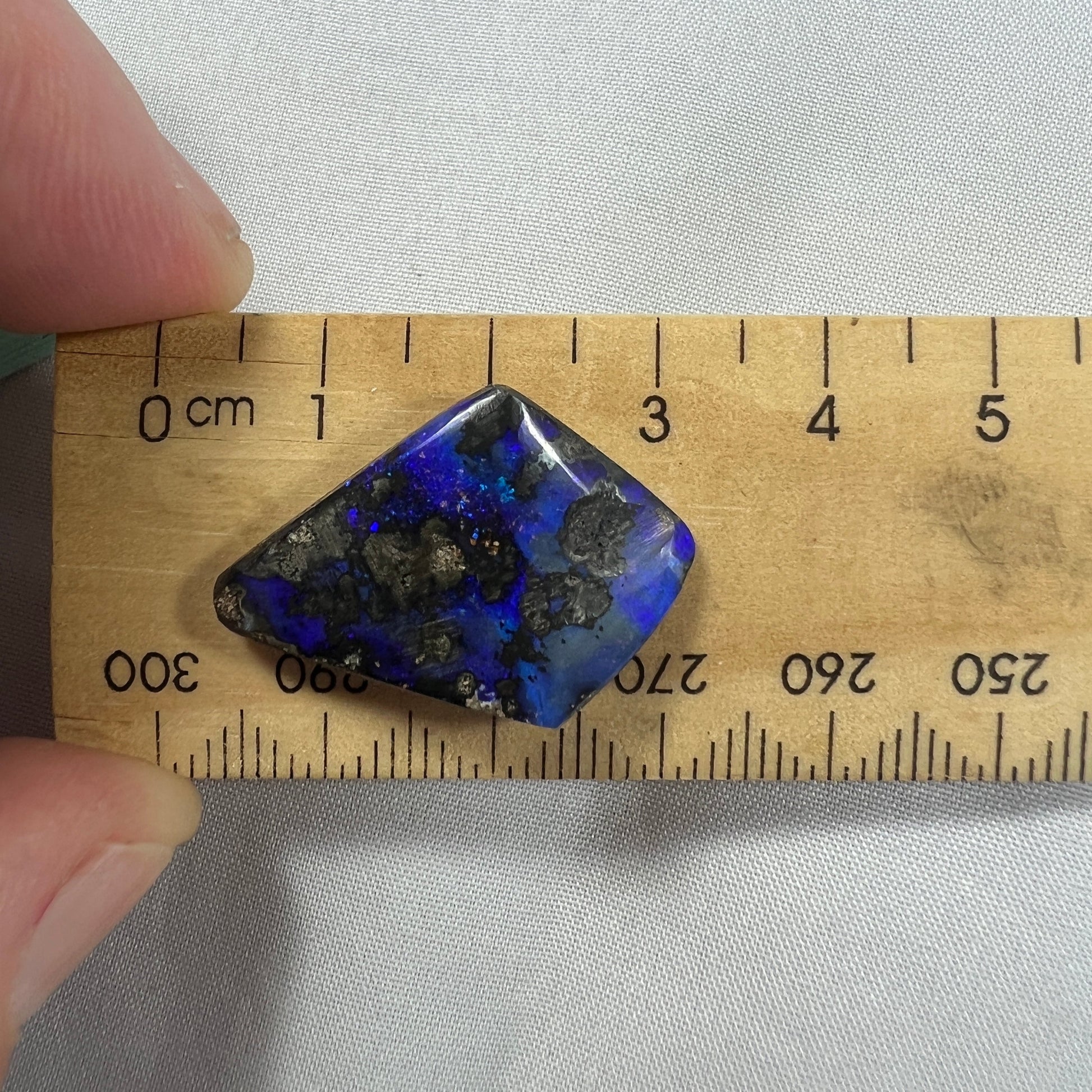 An unusual shaped piece of Winton boulder opal, showing beautiful blues.