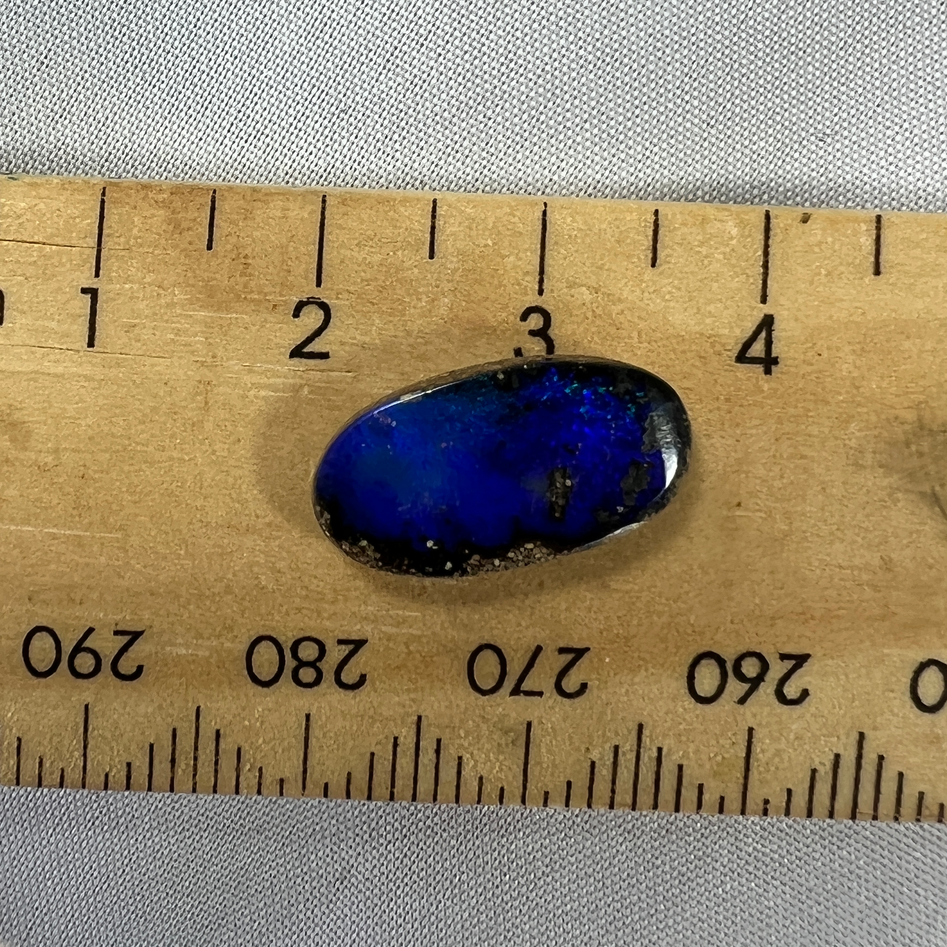 A great shaped little boulder opal with bright blues.